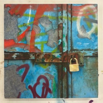 Blue metal door and lock with graffiti.